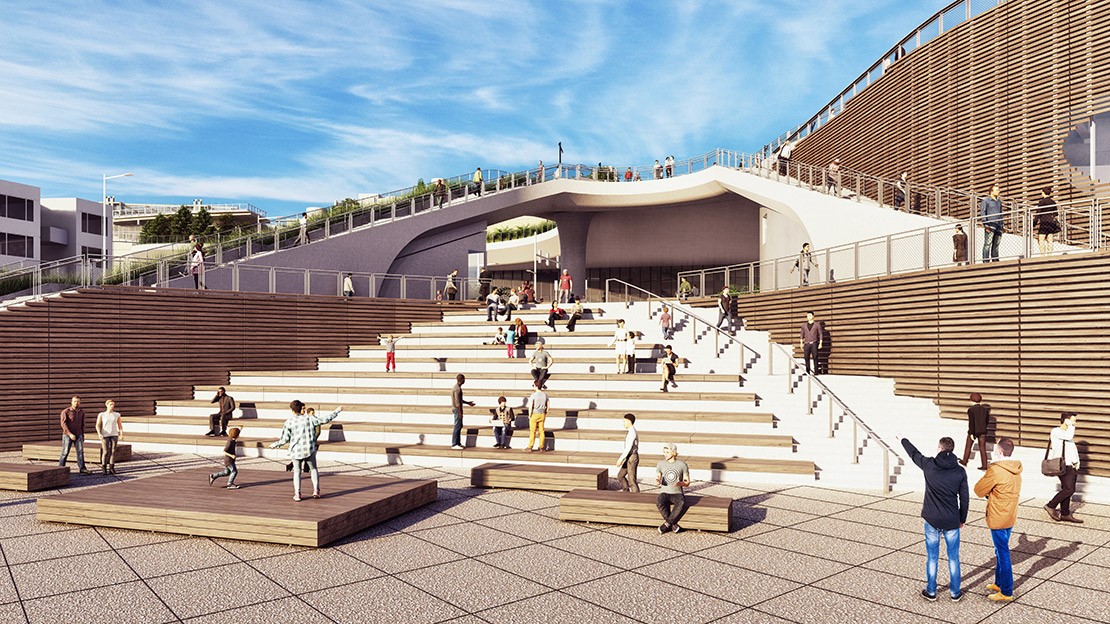 People congregate on steps that will double as an amphitheater. Small platforms with people on them sit at the bottom of the steps. 